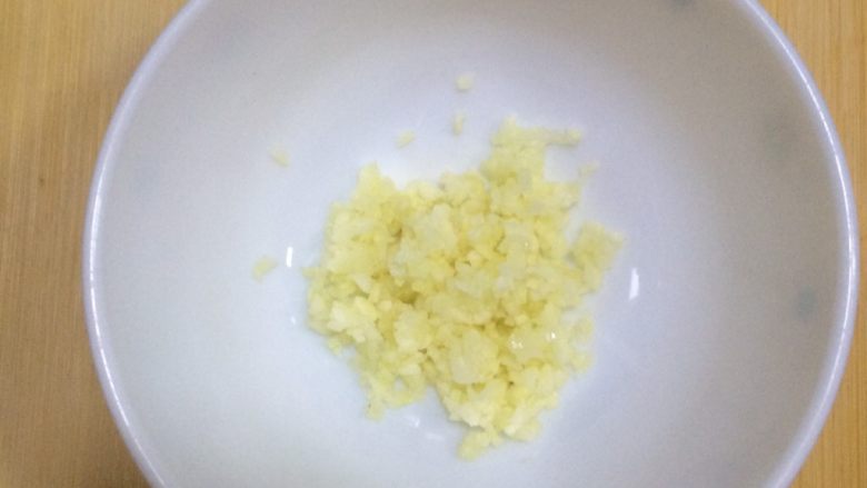 蔬菜蜜汁烤鸡腿,把蒜剁碎,放在碗内。