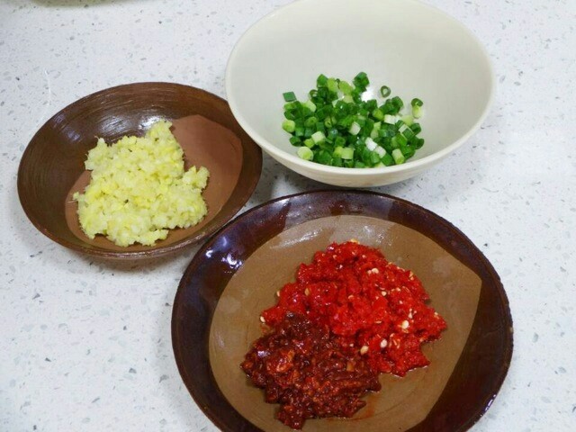 鱼香肉丝,分别把蒜粒姜切成碎粒一起装碗,把泡红椒和豆瓣酱切成碎状装碗,把葱切成小粒,单独装碗,备用