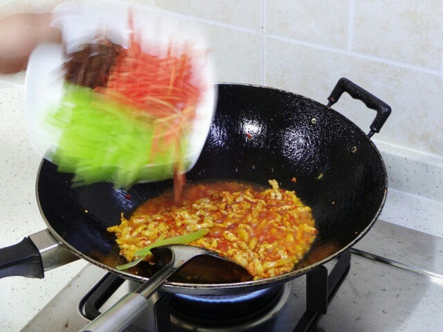 鱼香肉丝,混合均匀后迅速加入莴苣丝胡萝卜丝黑木耳丝继续翻炒均匀。