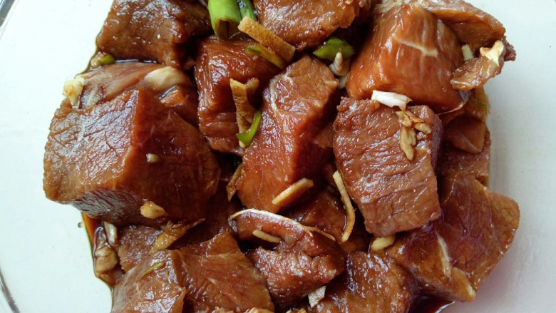 红烧牛肉炖鹌鹑蛋,戴上一次性手套用手轻轻按摩牛肉,再抓拌均匀,盖上盖子,放入冰箱腌制30分钟。