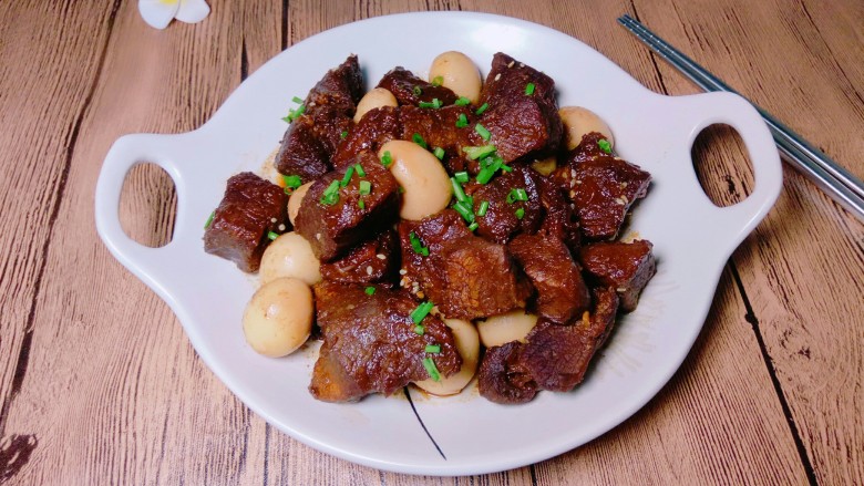 红烧牛肉炖鹌鹑蛋,出锅装盘,撒上葱花点缀,来吃吧!很美味的一道家常菜,鹌鹑蛋吸收了一些牛肉的汤汁也很入味。