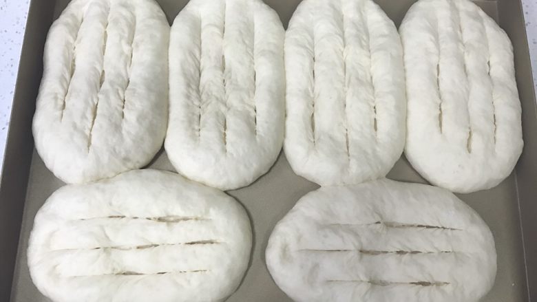 香葱培根芝士面包(咸香味),发酵好以后取出,用刀片在面包中上层竖着划三条。不要划到底。