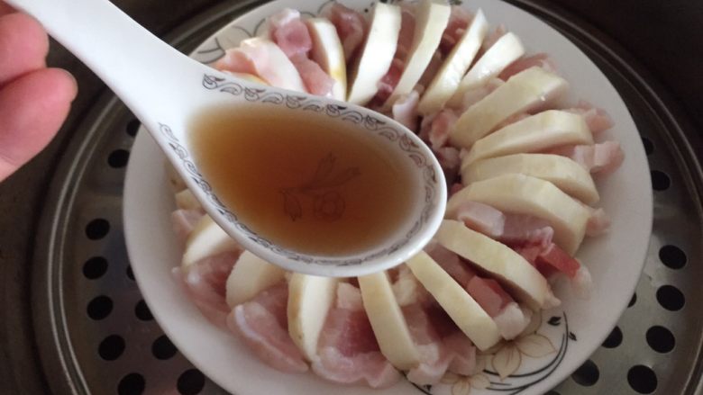 咸肉蒸芋艿,蒸锅里加入1/3锅水,盘子放在蒸架上,浇入一勺<a style='color:red;display:inline-block;' href='/shicai/ 894'>黄酒</a>。盖上盖子开锅煮,蒸20分钟。