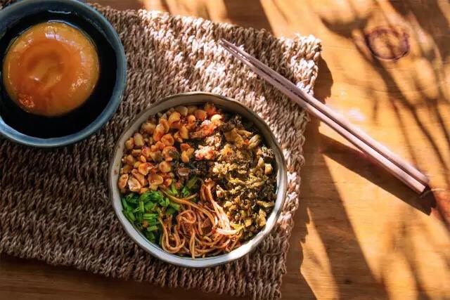 燃面和凉糕,铺入花生碎,肉末芽菜,撒葱花,完成。