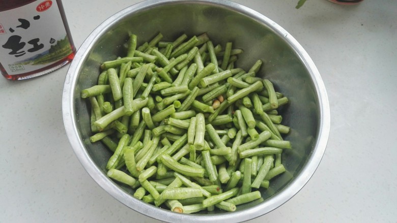 传统美食:蒸豆角,用筷子拌匀。