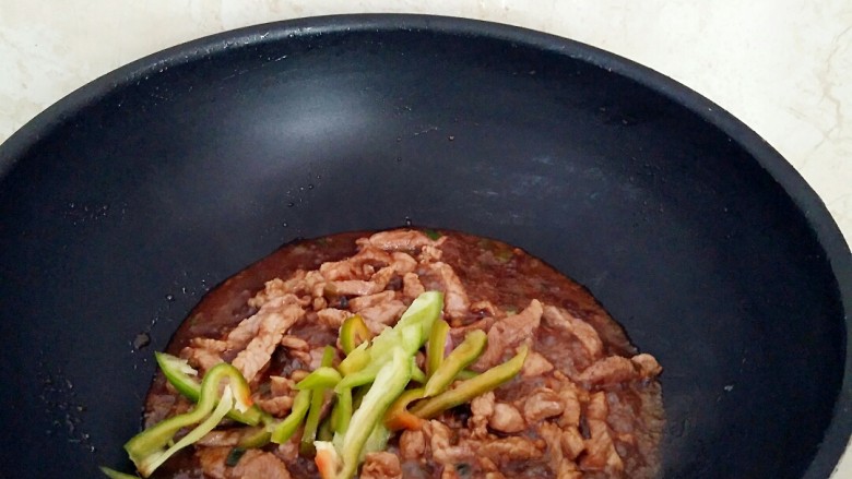 土豆酱肉丝卷饼,盖上锅盖中火烧制汤汁浓厚,放入青椒丝,撒上盐1克,拌匀出锅。