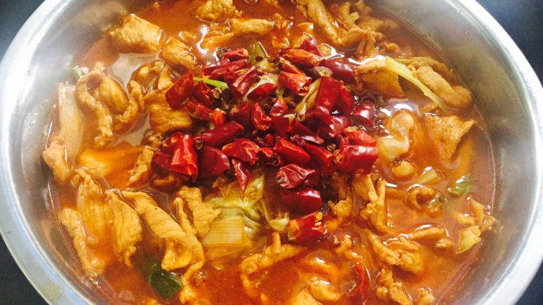 私房水煮肉片,把肉拨到汤汁里,撒上干花椒、干辣椒。起一口油锅,烧一些滚油。