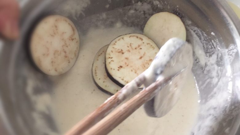 炸茄子,起油锅,将切好的茄子放入面糊内,均匀地裹上面糊