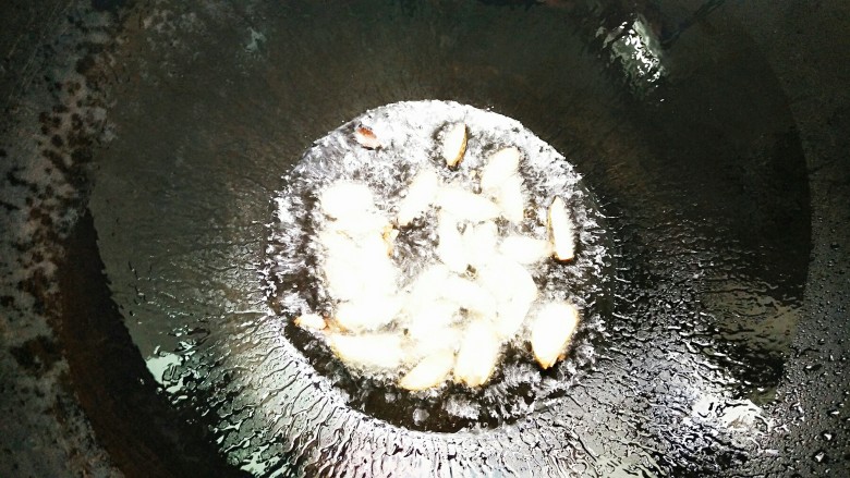 烟笋炒腊肉,锅里加入适量的油,把蒜片炒至金黄色即可!