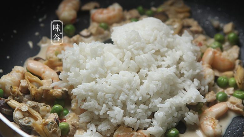 椰子海鲜芝士焗饭,最后把煮好的米饭倒入锅内,翻炒均匀;