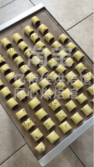 红豆一口酥,原方是酥油,我用的是黄油,黄油室温软化加糖粉至微发,慢慢分次加入蛋液<a style='color:red;display:inline-block;' href='/shicai/ 865'>蜂蜜</a>混合液,一定要温度接近,要么就是水油分离及根本没办法混合,所以这里重中之重,就是一定都要常温,吸收进去再加,因为蛋液量比较大,我自己感觉还是比较不容易混合打发的
提前将粉类过筛一遍
加入已经打发好的黄油液,戴上手套混合至无干粉即可,不要过度揉拌,防止粉类上筋
然后将面团静置三十分钟后操作
然后将红豆沙搓成细柱状,将面团擀成细圆柱长度,宽度足够包裹细圆柱一圈的宽度即可(最好保鲜膜上操作)要么你根本没办法掀起来做包裹动作,这会如果觉得粗了,可以再冷冻后再拿出来再搓搓,达到你满意的粗细长度
都整形好后送入冷冻室,冷冻二十分钟,再刷好蛋黄液,切段,摆入烤盘中,撒上黑芝麻装饰