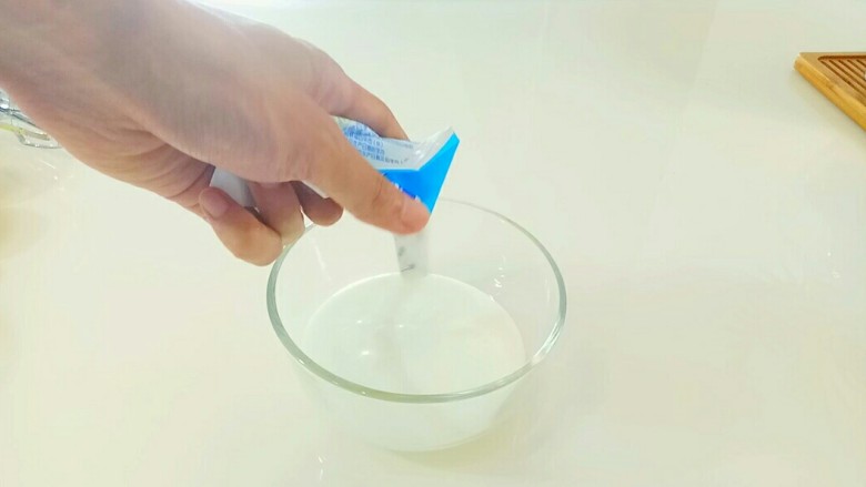 嫩口酸奶蒸蛋,将一袋<a style='color:red;display:inline-block;' href='/shicai/ 885'>酸奶</a>挤入搅拌碗中。