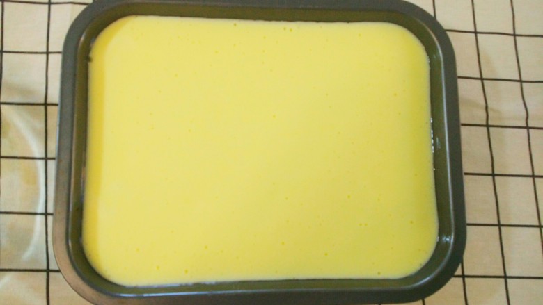 嫩口酸奶蒸蛋,把酸奶糊倒进盘子里，用手振动几下。