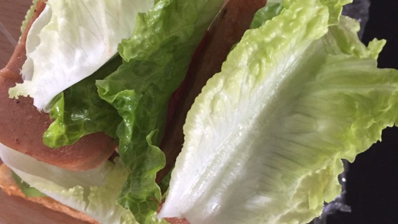三明治里的爱马仕--厚吐司, 再铺上午餐肉和生菜,记得按压一下,让整个三明治结实一点,才不容易松散。