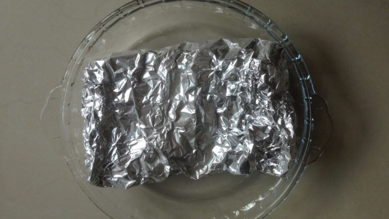 烤猪肉三明治,用锡纸包好猪肉片,放在烤盘里。