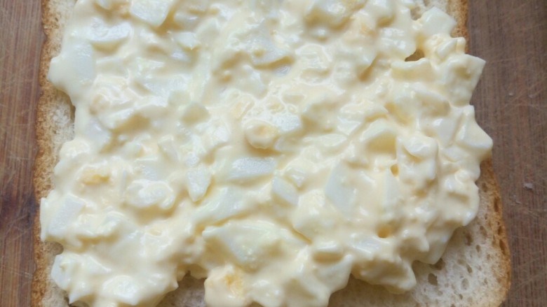 鸡蛋三明治,先拿一片把夹心铺上。