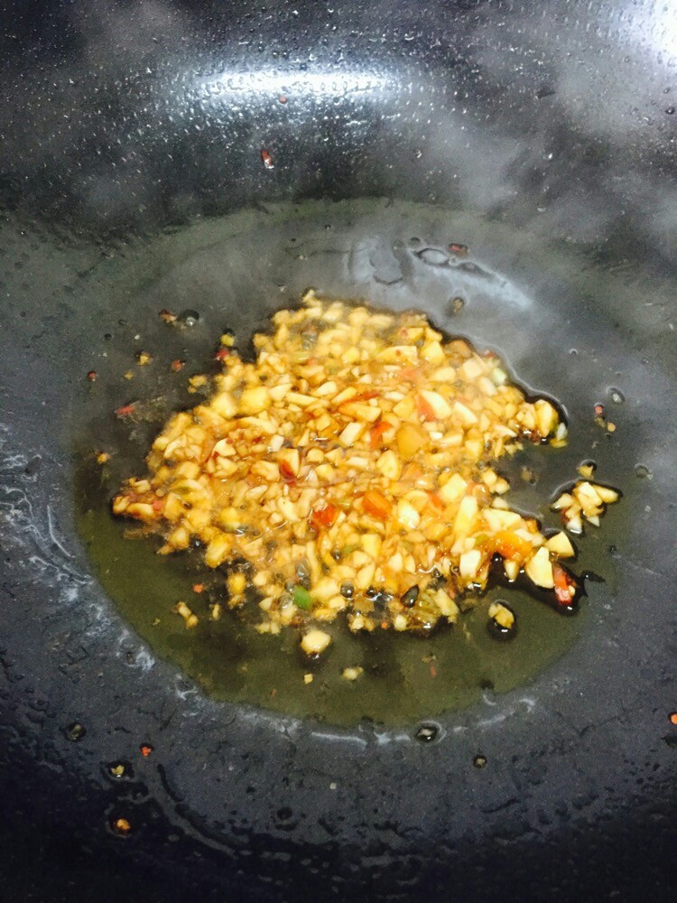 香辣凉拌皮蛋,少量油下锅,小火油六成热时就可以放入蒜末,微炒下就倒入姜末一起翻炒。