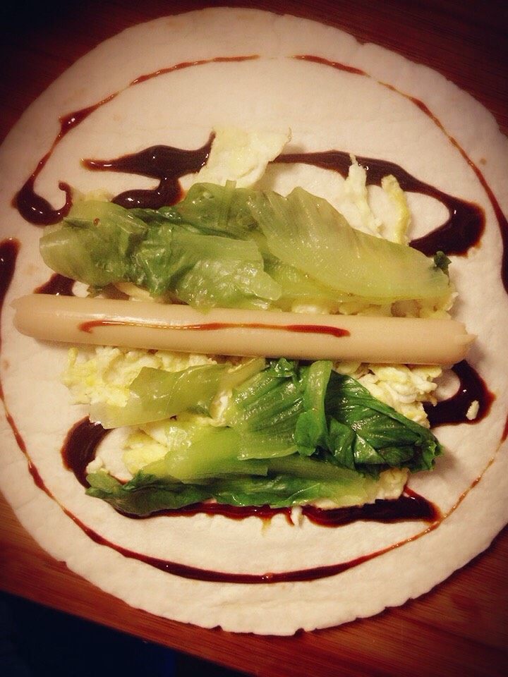 卷饼,饼皮上淋上<a style='color:red;display:inline-block;' href='/shicai/ 712'>甜面酱</a>，鸡蛋，<a style='color:red;display:inline-block;' href='/shicai/ 121'>生菜</a>（用沸水烫一下即可），<a style='color:red;display:inline-block;' href='/shicai/ 425'>香肠</a>，然后卷起来，切成两半
