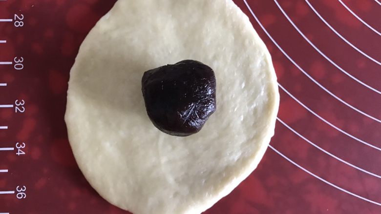 小乌龟菠萝包,取一个面团,擀成中间厚周围薄的面片,包上豆沙,封口捏紧,揉圆。