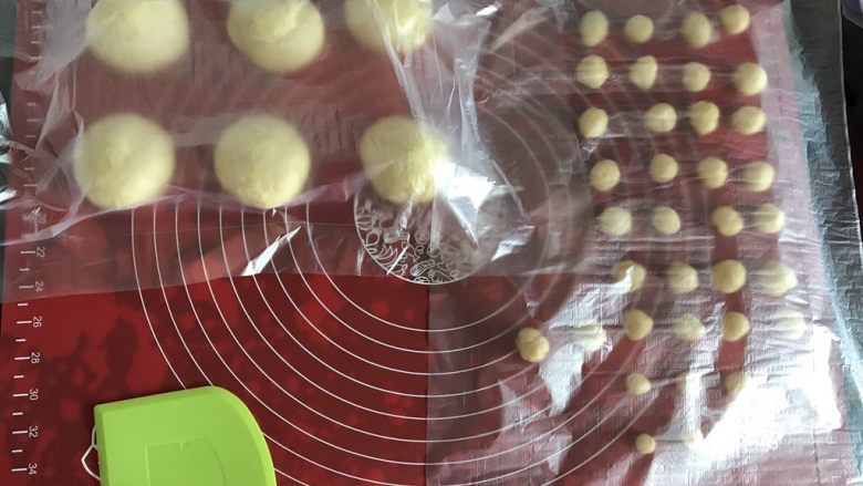 小乌龟菠萝包,发酵好的面团取出排气,平均分成8份,其中两份分成36份做小乌龟的头、脚和尾巴。揉圆,盖上保鲜膜醒发15分钟。