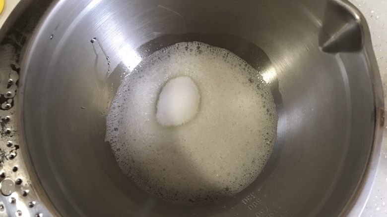 巧克力可可蛋糕卷,开动电动打蛋器低速将蛋白打至鱼眼状,加入细砂糖,继续高速转低速打发蛋白霜。