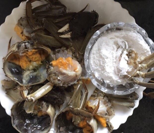 蒜泥螃蟹,锅中放适量的油烧热,螃蟹的切口部位蘸裹上淀粉(生粉一样)