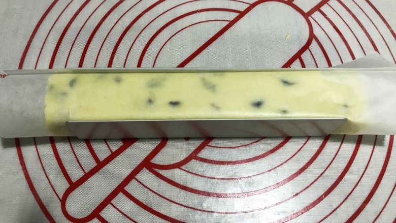 蔓越莓曲奇(香酥不变形),放入模具,冰箱冷冻20-30分钟(冷冻、冷冻、是冷冻!)
取一张不粘油纸,裹住长条面团。放入模具中,压平上端,放入冰箱冷冻20-30分钟。