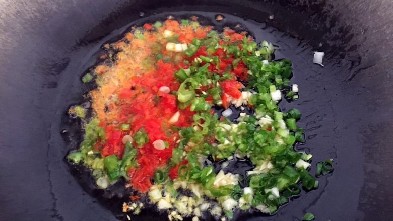 蒸茄子,热锅，锅中放入油加热，依次放入切好的红辣椒，湖南椒，蒜和葱爆香。