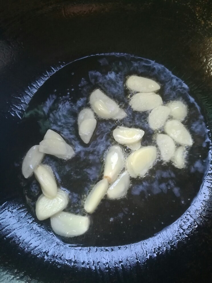 蒜苗炒卤鸭胸,坐锅热油,下蒜片小火煸香。