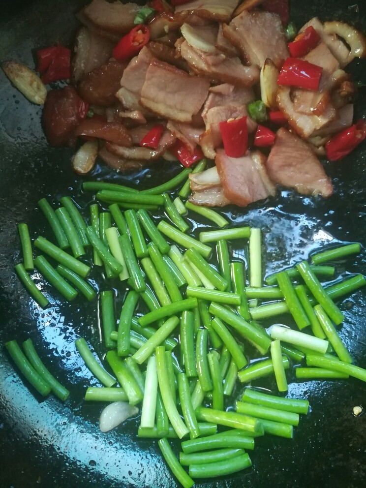 蒜苗炒卤鸭胸,炒过的食材又扒在一边,下蒜苗炒二十秒。