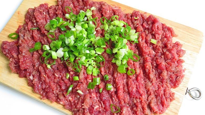 羊肉煎饺,羊肉切成大块后剁成肉泥,再加入葱碎,滴几滴油继续剁,细腻即可