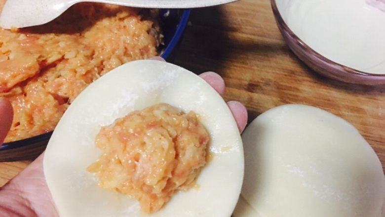 莲藕肉馅饺子,把肉馅放饺子皮中间,用右手食指沾点水,涂在饺子皮外围四周。