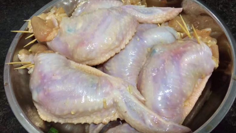鸡翅包饭,将炒饭用汤匙一点点塞进鸡翼内,再用牙签把口封好,不要塞太满,会容易爆开!如果起骨起破洞了,同样用牙签封好口即可!