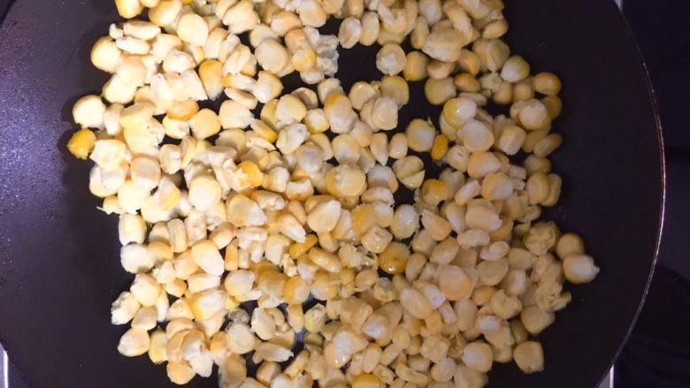 金沙玉米,热锅热油,下玉米粒,待表面形成薄薄外皮时翻炒。