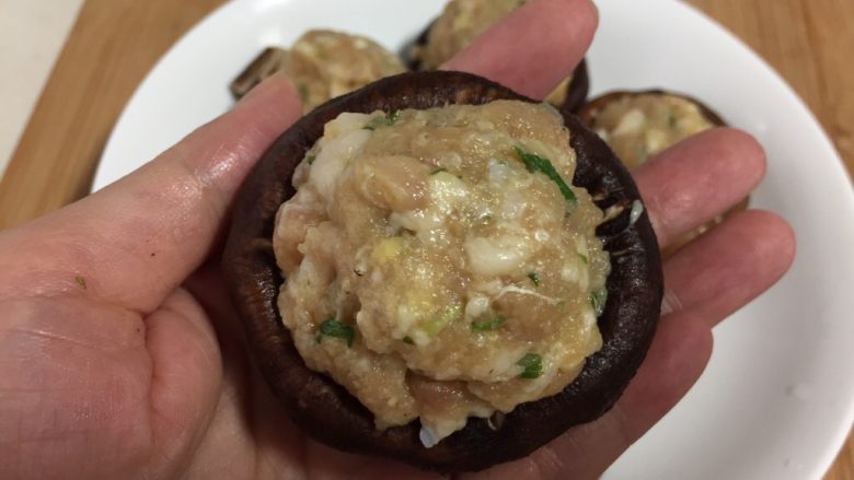 香菇酿肉,把做好的肉馅装进香菇里,整齐的码在盘子里。