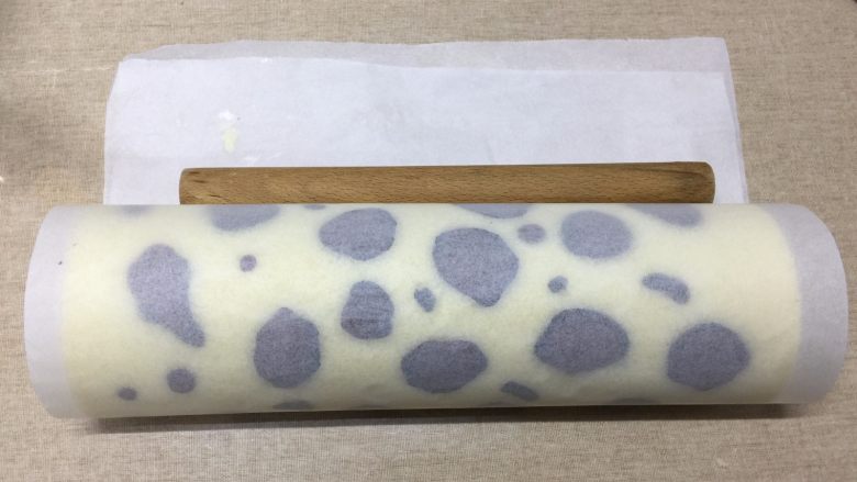 豹纹蛋糕卷,猎到你了吗?,擀面杖放在起始端的油纸下面,连同油纸一起提起,向前卷,最后要往后收压,使蛋糕卷更紧实
