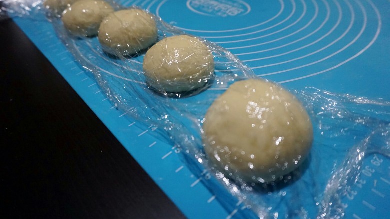面包超人,揉好的面团放在案板上,上面盖保鲜膜,松弛10分钟。