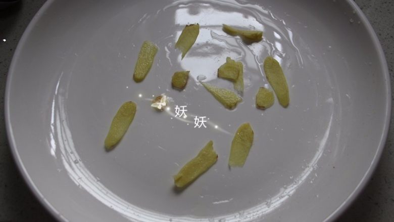 剁椒鱼头,取一个大盘子,底部先铺上少量的姜片。
