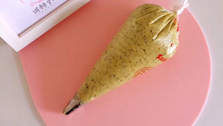 黑芝麻核桃粉曲奇, 面糊做好以后,用裱花袋将曲奇面糊挤在烤盘上了