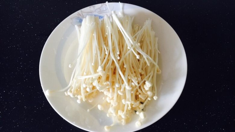 番茄金针菇肥牛,金针菇切去老梗,洗干净备用。