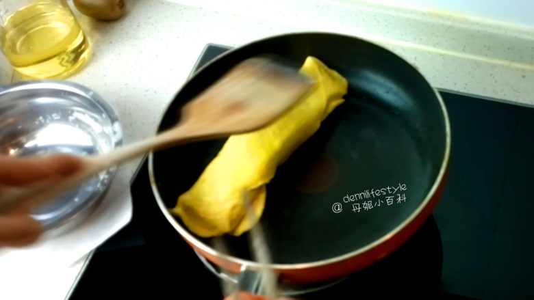 海苔双色蛋卷,等到底面凝固,表面还没有凝固时,从蛋白卷一侧将蛋黄卷起