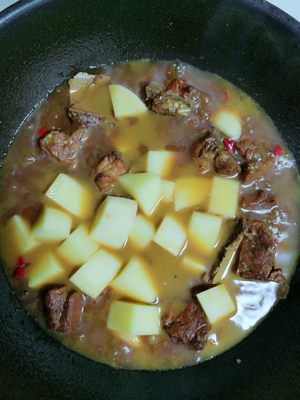 土豆排骨浇饭,半个小时后加入土豆块再焖半个小时,在这期间加入一小勺盐(可以根据自己的口味做出调整)