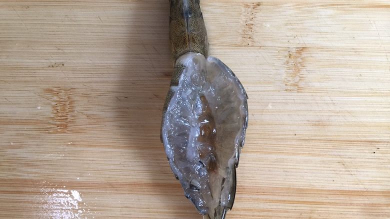 砂锅粥—鲜虾粥,用刀划开虾背,挑去虾线。