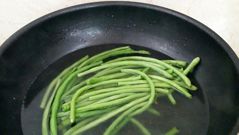 鲜肉豆角锅贴,烧开水，放入豆角戳水去除碱性。