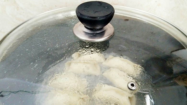 鲜肉豆角锅贴,倒入清水,水量刚好莫过锅贴底部就行,盖上锅盖闷烧。