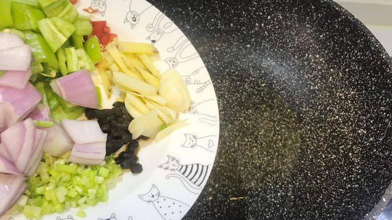 酱爆鱿鱼足,锅中倒入少许色拉油,先放入姜丝蒜片和豆豉