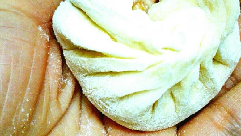 粉条菜包,拇指支住面皮,食指开始均匀地打摺收皮,收好按以下