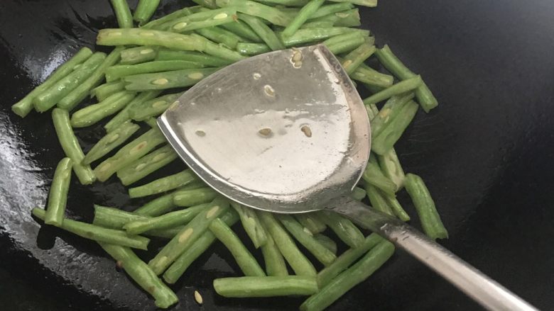 四季豆烧茄子,下入四季豆,并用锅铲按压,煸炒
