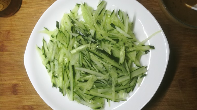 不一样的麻酱凉面,<a style='color:red;display:inline-block;' href='/shicai/ 54'>黄瓜</a>擦丝,摆在盘底。没有擦丝板的我只能手切。