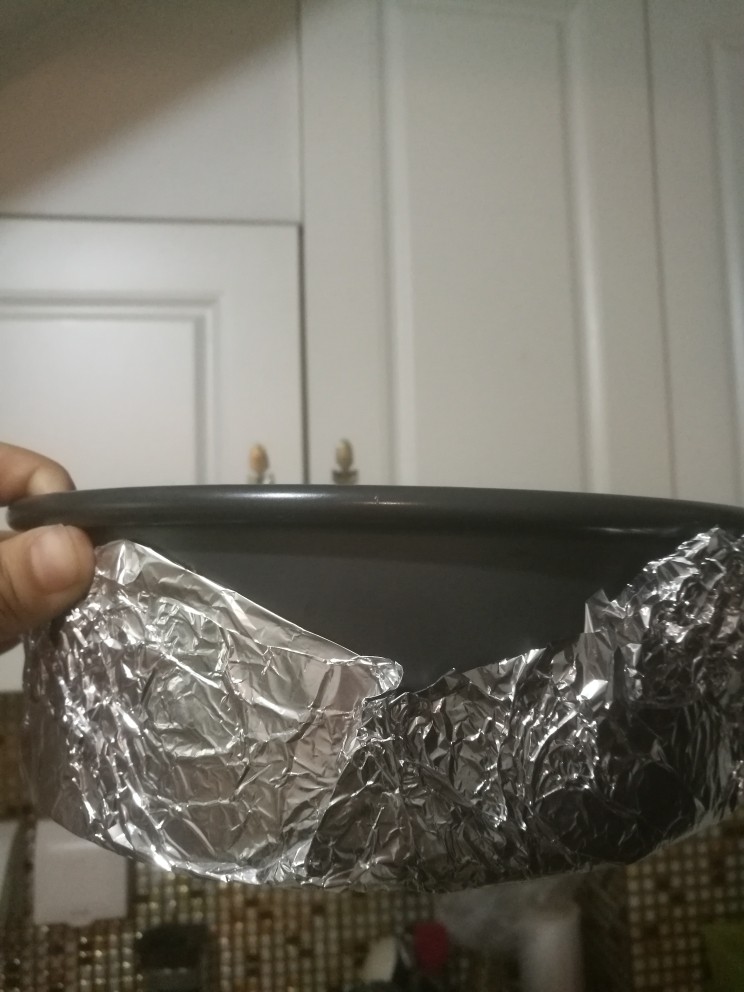 咖啡味神奇魔法蛋糕,活底的模具,一定要在外面先裹一层锡纸。或者里面全铺油纸,铺油纸的话比较容易脱模。此款蛋糕面糊特别稀,所以一定不要忘了。